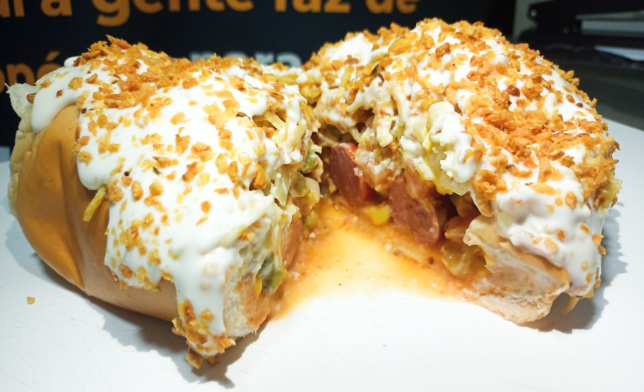 Cachorro-quente aberto cortado ao meio mostrando as camadas de recheio